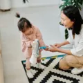 Cara membangun disiplin anak dengan mengajak merapikan mainan bersama secara ceria di ruang keluarga