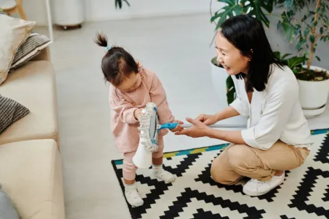 Cara membangun disiplin anak dengan mengajak merapikan mainan bersama secara ceria di ruang keluarga