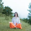 Seseorang sedang melakukan meditasi tenang di alam terbuka untuk menerapkan cara mengurangi stres