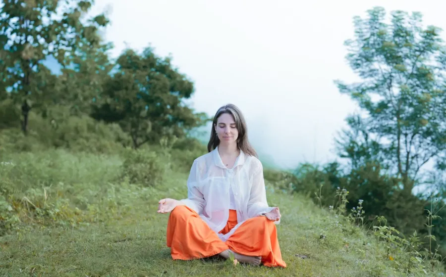 Seseorang sedang melakukan meditasi tenang di alam terbuka untuk menerapkan cara mengurangi stres