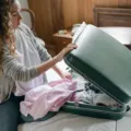 Persiapan sebelum traveling dengan menata pakaian dan dokumen di dalam koper