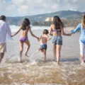 Tips wisata bersama keluarga ceria saat menikmati liburan di pantai berpasir putih