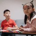 Aktivitas anak di rumah sedang bermain membuat kerajinan tangan bersama saudara
