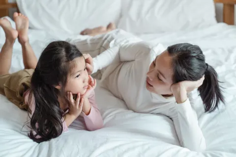 Ibu dan anak sedang mengobrol dengan ceria sebagai bagian dari cara membangun komunikasi dengan anak