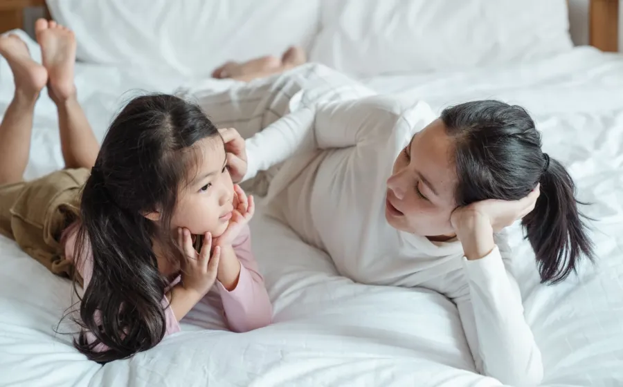 Ibu dan anak sedang mengobrol dengan ceria sebagai bagian dari cara membangun komunikasi dengan anak