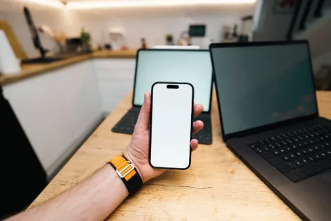 Seseorang sedang membandingkan dua gadget di toko untuk memilih perangkat sesuai kebutuhan harian