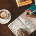 Seseorang sedang merapikan buku agenda untuk mengatur rutinitas harian yang produktif