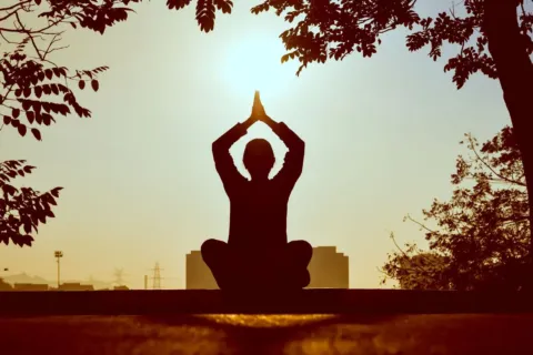 Seseorang sedang bermeditasi dengan tenang untuk menjaga kesehatan mental agar terhindar dari stres harian