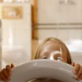 Anak kecil sedang belajar merapikan mainan sendiri untuk melatih kemandirian anak sejak dini