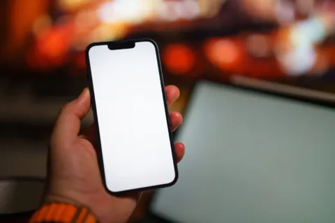 Seseorang sedang membandingkan dua gawai baru sebagai tips membeli smartphone yang tepat