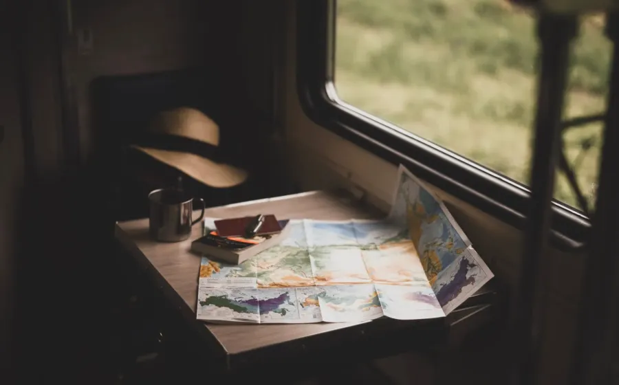 Ilustrasi tips membuat itinerary perjalanan dengan peta wisata dan catatan rencana liburan