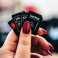 Tangan memegang kartu memori microSD dan SD card untuk kamera serta ponsel