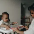 Dua anak balita sedang main balok kayu bersama di ruang keluarga