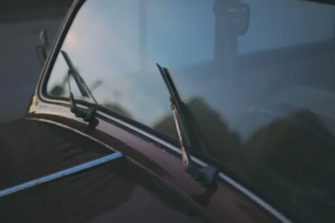 Langkah praktis dalam cara merawat kaca mobil untuk menjaga visibilitas berkendara tetap jernih saat hujan deras.