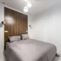 Ide dekorasi kamar tidur sempit fungsional dengan lampu hangat dan cermin besar