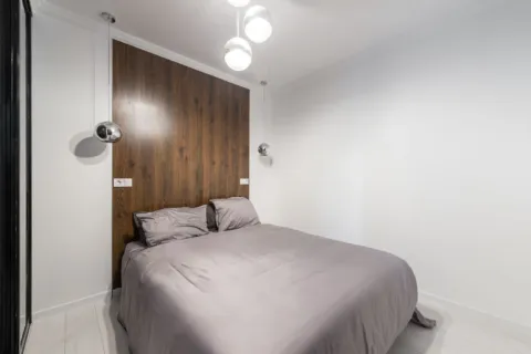 Ide dekorasi kamar tidur sempit fungsional dengan lampu hangat dan cermin besar