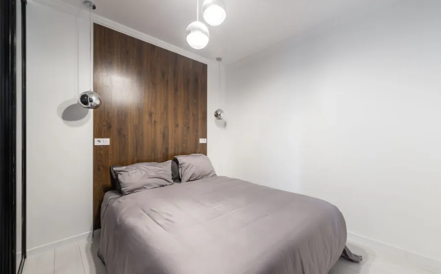 Ide dekorasi kamar tidur sempit fungsional dengan lampu hangat dan cermin besar