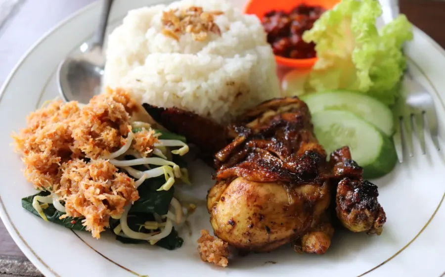 Makanan untuk kesehatan tubuh berupa piring berisi sayuran hijau, tempe, dan buah segar