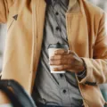 Pria mengenakan jaket fungsional berwarna gelap sedang bersiap mengendarai motor di perkotaan