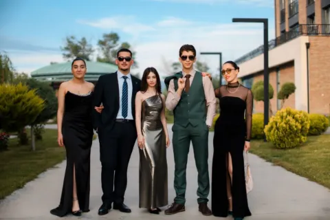 Deretan pakaian pesta elegan di gantungan baju yang rapi untuk acara formal dan semi formal