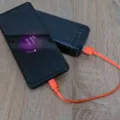Tips memilih power bank yang aman sedang mengisi daya baterai ponsel pintar di meja
