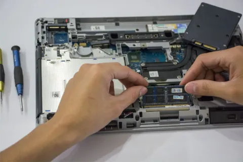 Teknisi sedang memasang SSD dan RAM untuk meningkatkan performa komputer
