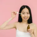 Urutan cara memakai skincare harian yang benar dengan mengoleskan serum pada wajah