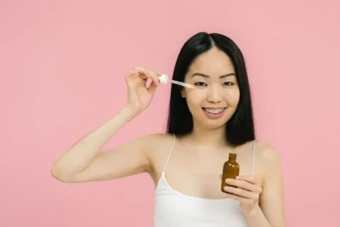 Urutan cara memakai skincare harian yang benar dengan mengoleskan serum pada wajah