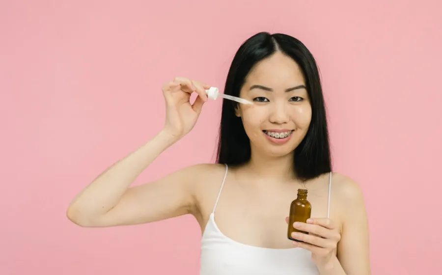 Urutan cara memakai skincare harian yang benar dengan mengoleskan serum pada wajah